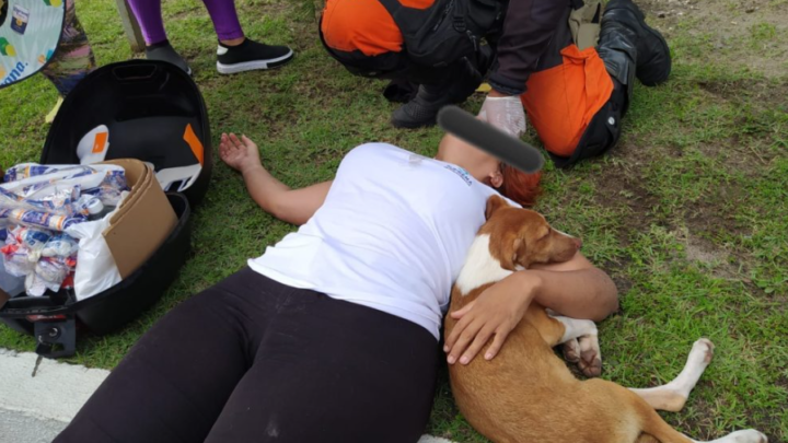Cachorro provoca acidente de moto e fica ao lado de mulher durante socorro dos bombeiros