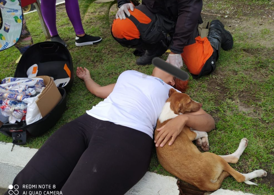 Cachorro provoca acidente de moto e fica ao lado de mulher durante socorro dos bombeiros Cachorro provoca acidente de moto e fica ao lado de mulher durante socorro dos bombeiros
