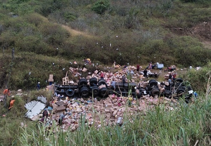 Caminhoneiro morre após carreta capotar, e carga de calçados é saqueada Caminhoneiro morre após carreta capotar, e carga de calçados é saqueada