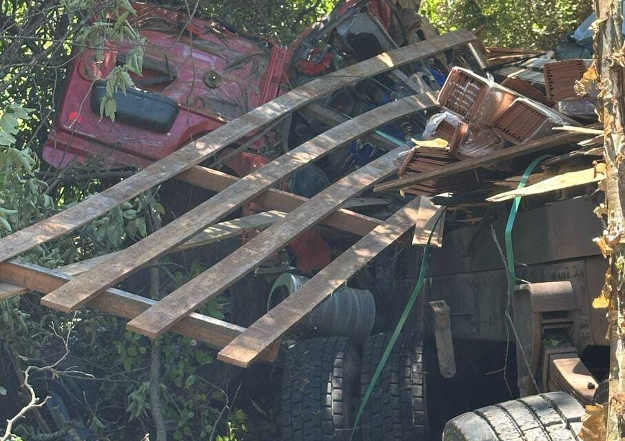 Passageiro morre e motorista fica ferido, após caminhão tombar Passageiro morre e motorista fica ferido, após caminhão tombar