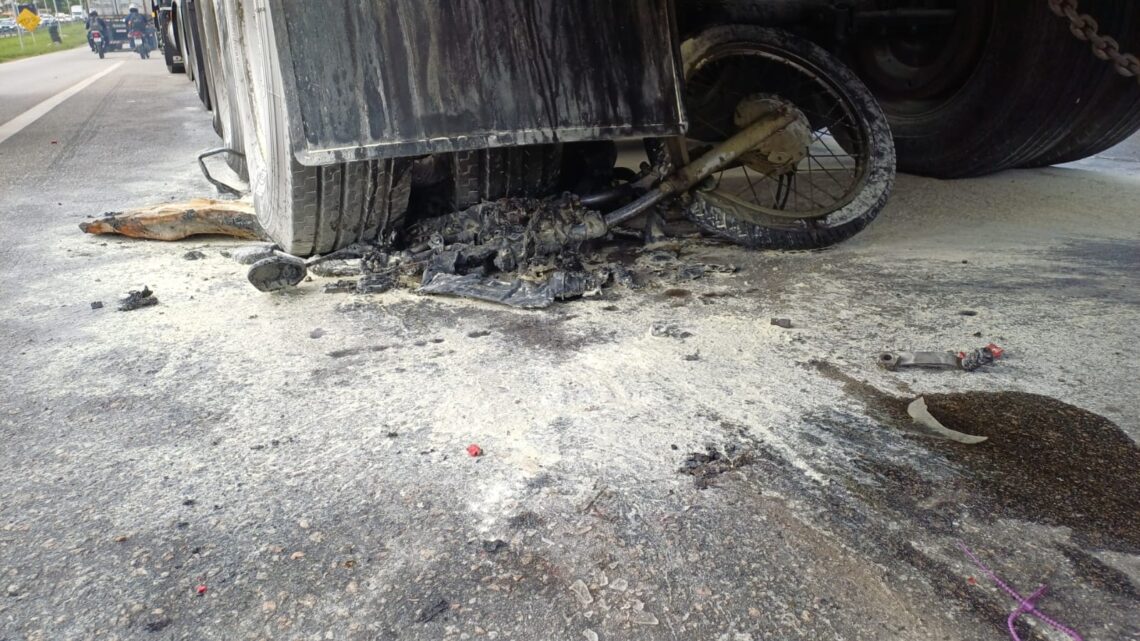Moto cai embaixo de carreta e pega fogo Moto cai embaixo de carreta e pega fogo