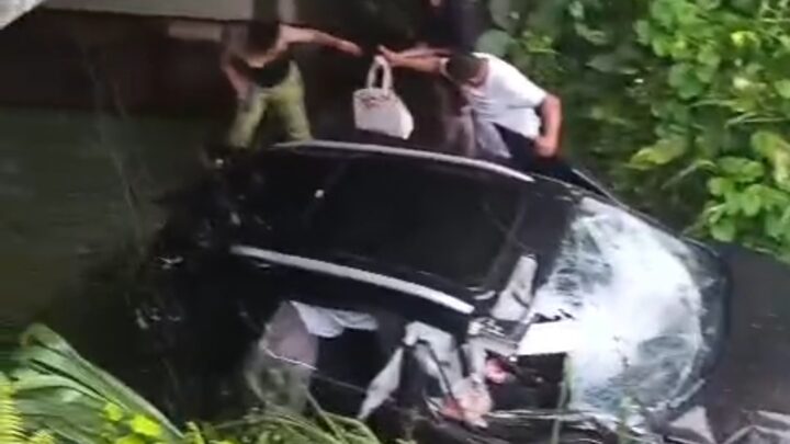 Carro derrapa com pista molhada e cai em vala